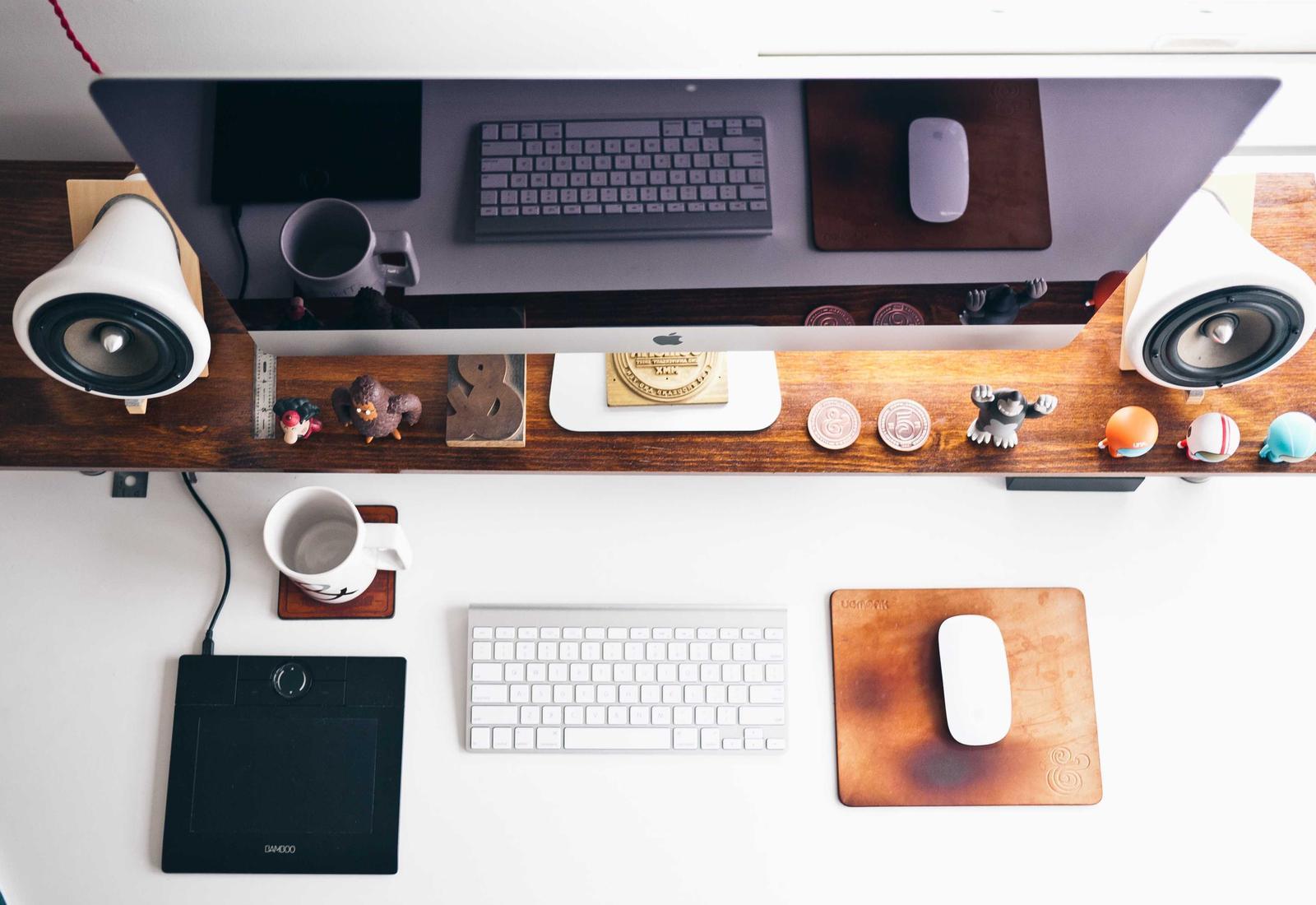 A tidy desk with a computer, keyboard and tablet