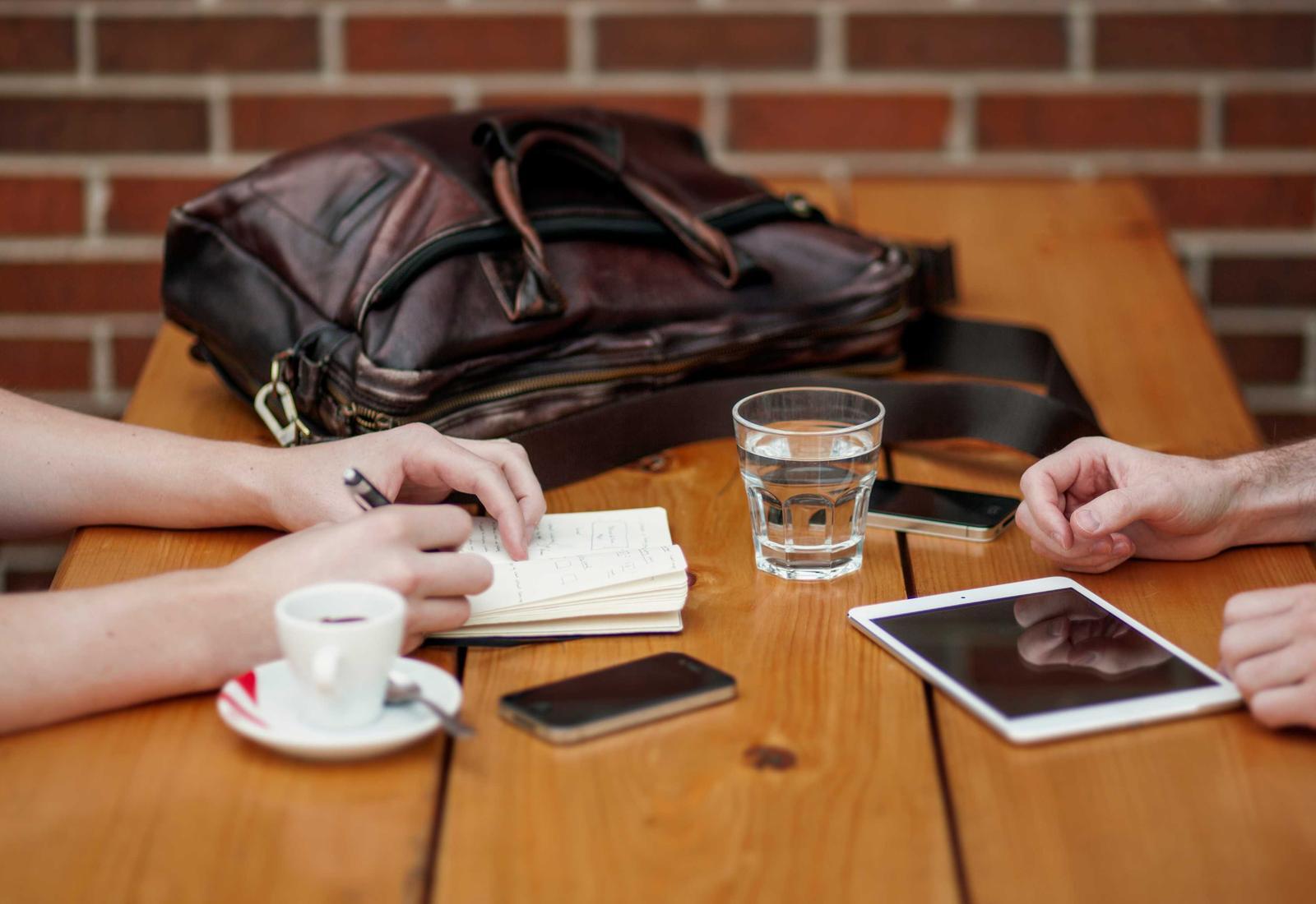 Colleagues meeting around a table with notes and a tablet